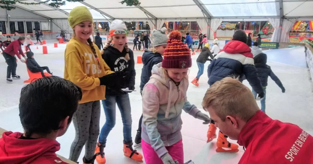 Kinderen leren schaatsen tijdens het schoolschaatsen
